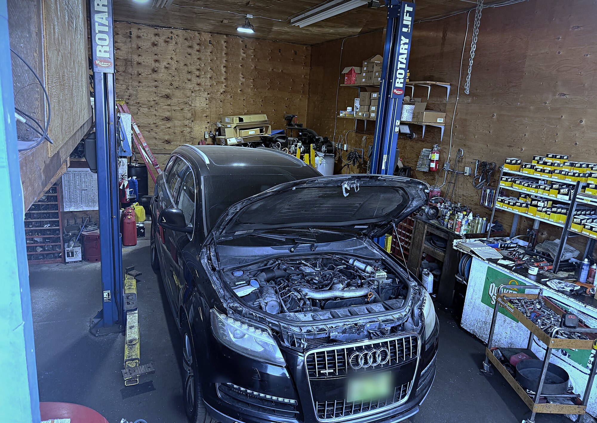 An Audi Q7 in the bay with the hood up, mid-diagnosis at A-T Auto Repair.
