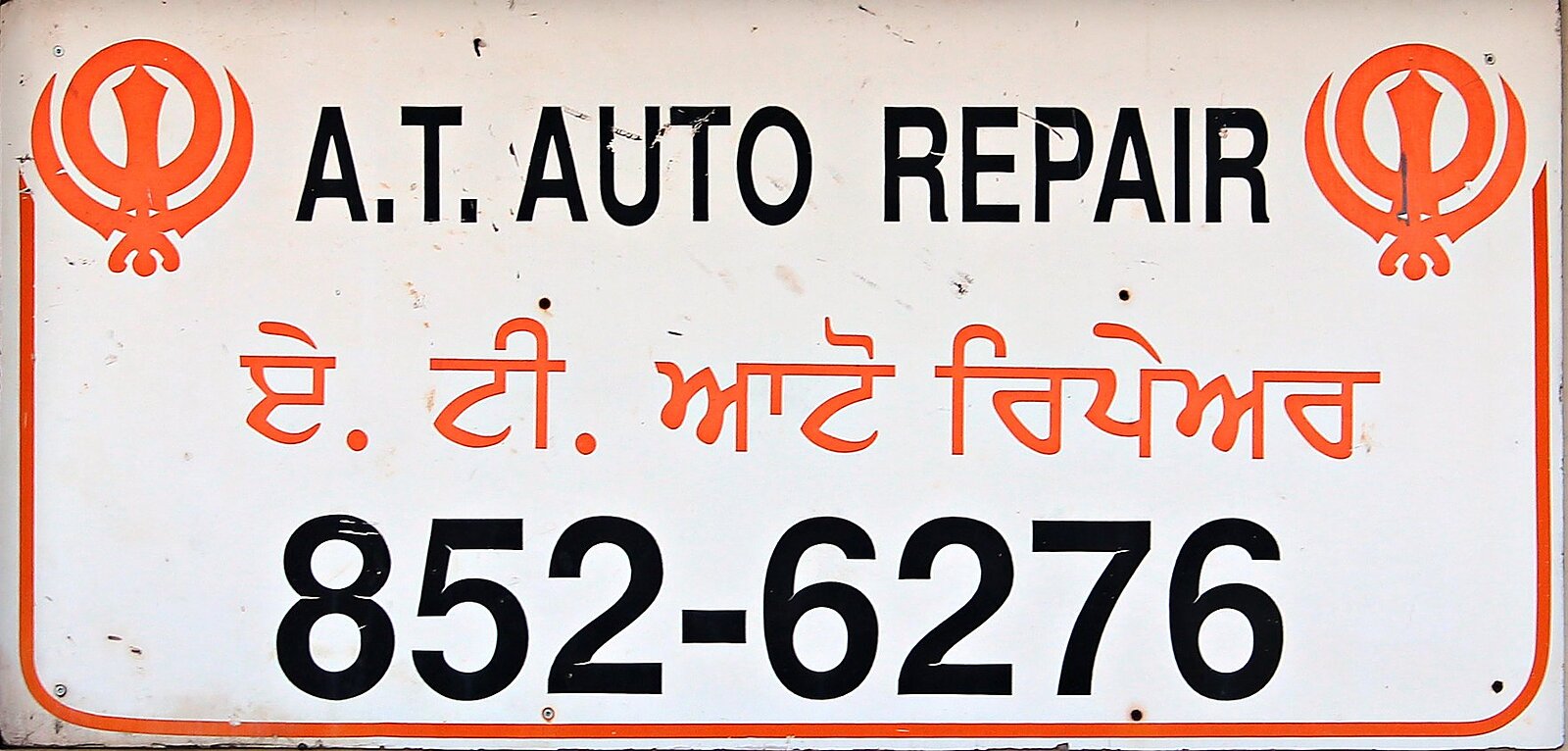 The shop's own sign in English and Punjabi — A.T. Auto Repair · ਏ. ਟੀ. ਆਟੋ ਰਿਪੇਅਰ · 852-6276.