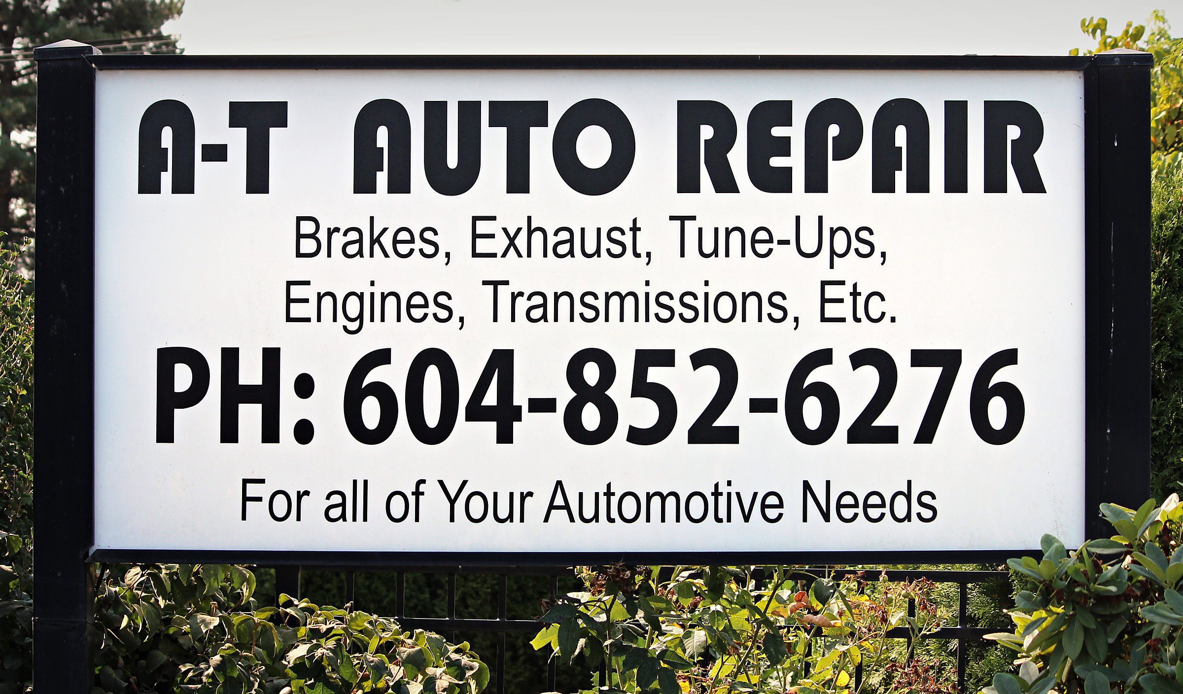 The A-T Auto Repair sign on Townline Road — brakes, exhaust, tune-ups, engines, transmissions. PH 604-852-6276.