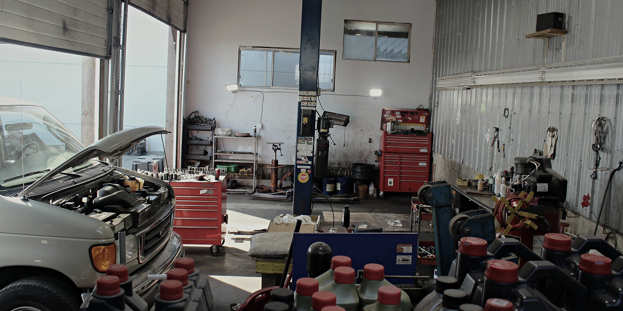 Inside the bay at A-T Auto Repair — a van in for service, the lift, and the day's tools.